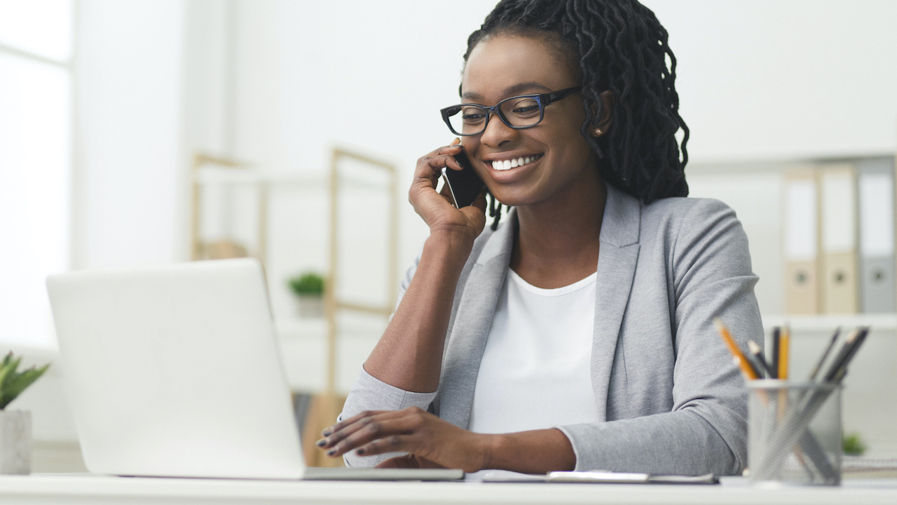 Professional on computer and phone in an office.