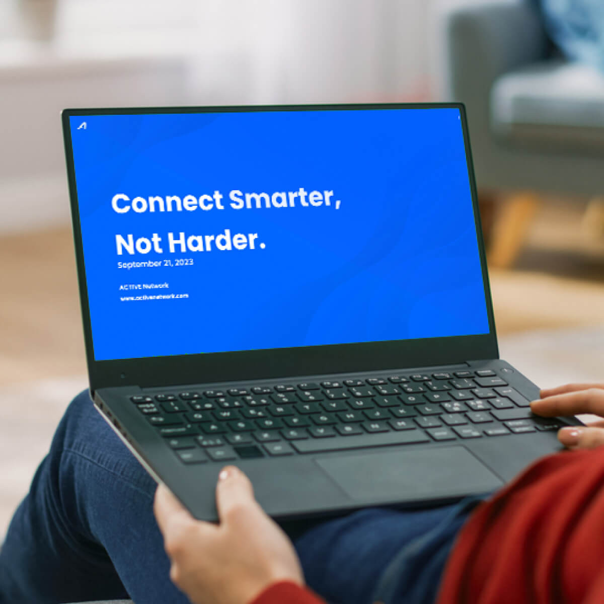 person with red shirt watching the pre-recorded active connect webinar on their computer at home